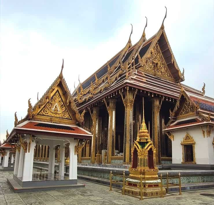 The golden structure of Wat Phra Kaew (The Temple of the Emerald Buddha) with detailed gold and silver columns and an elaborate pitched roof, in Bangkok,Thailand