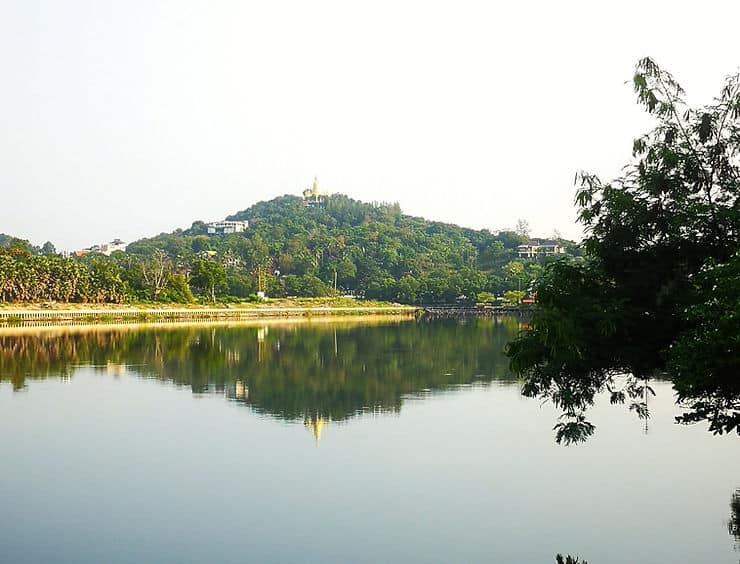 A walking path follows the edge of Chaweng Lake in Koh Samui, Thailand, lined with trees