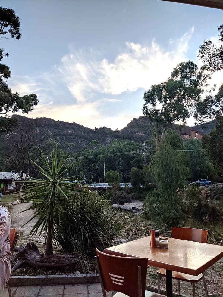 An outside restaurant table in the town of Halls Gap faces a views of the mountains of the Grampians National Park 