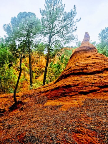 Bright orange rock formations made of ochre in Roussillion's old ochre quarry