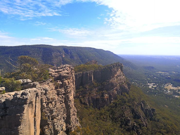 Rocky cliffs jut out of the mountainside at the Pinnacle Lookout, with a sheer drop to the green valley below