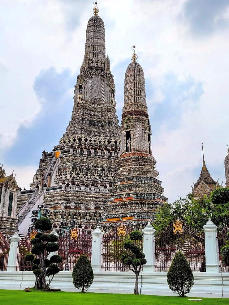 Wat Arun's central pagoda stands tall amongst one of the 4 smaller towers and the other temple buildings - Bangkok.