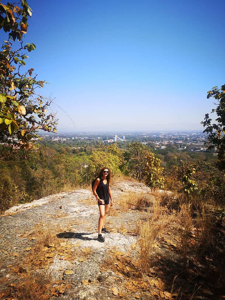 Looking down across trees at Huay Keaw waterfall viewpoint, views of Chiang Mai can be seen in the background