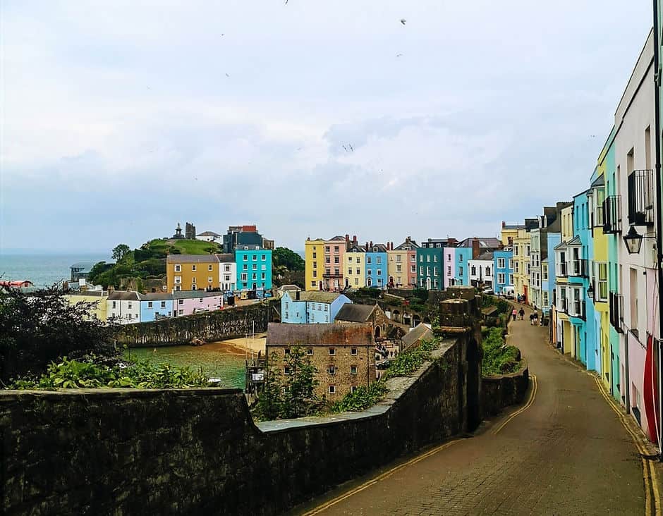A row of brightly coloured houses look out onto Tenby beach