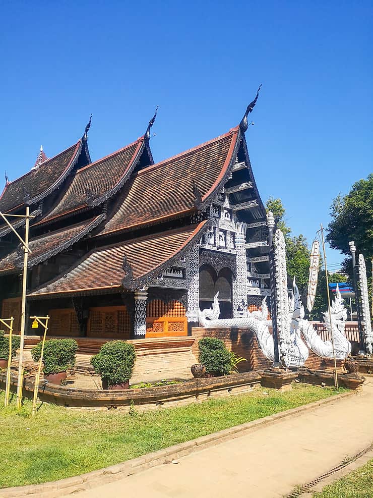 Wat Lok Moli is a understated temple with a tiered red tiled roof and white facade with two white dragons at the entrance