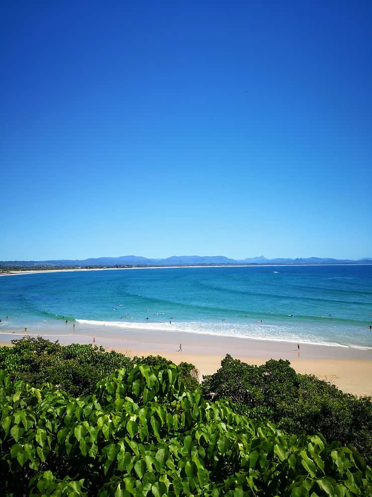Looking over the treetops, down to Clarke's beach, and in the distance, Belongil beach with the deep blue sea spanning the shorelinein Byron Bay