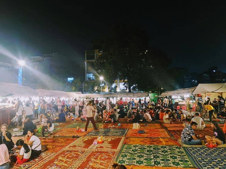 People crowd round the street food stalls at Phnom Penh night market in Cambodia