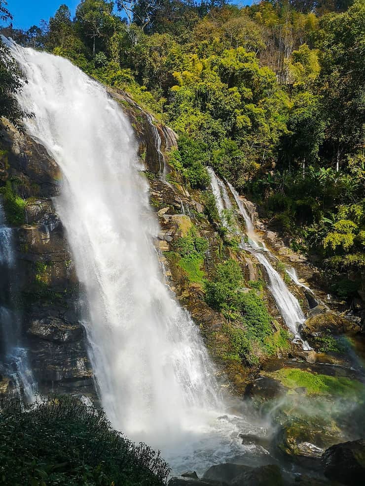 The Wachirathan Waterfall is short, but full and wide, surrounded by the forest