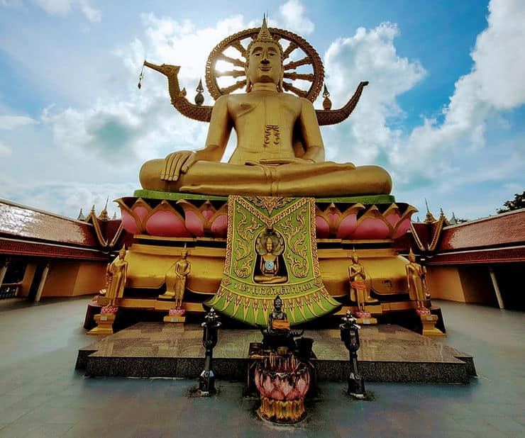 A large Golden Buddha statue sits cross legged.