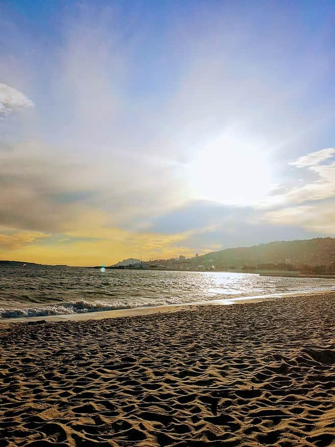 The sun sets over the sandy beach in Juan les Pins, France