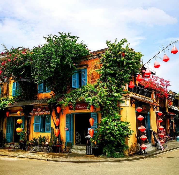 A bright yellow building is adorned with red lanterns in Hoi An Ancient town, Vietnam