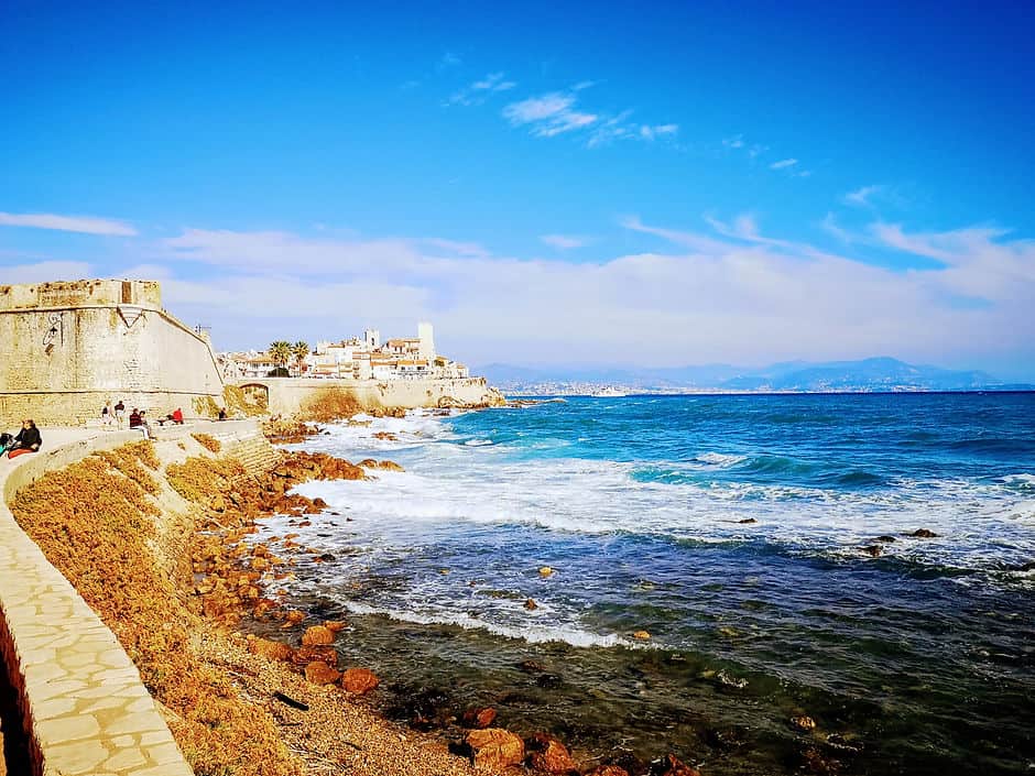 Waves crash against the stone ramparts of Antibes Old Town 