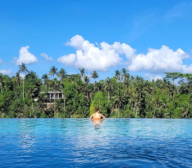 A woman in an infinity pool, surrounded by jungle views, Ubud, Bali