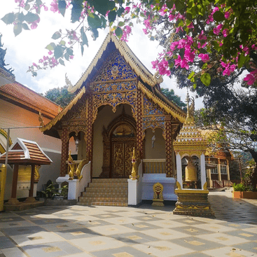 A small temple building, decorated with a gold roof and blue and gold patterned tiles
