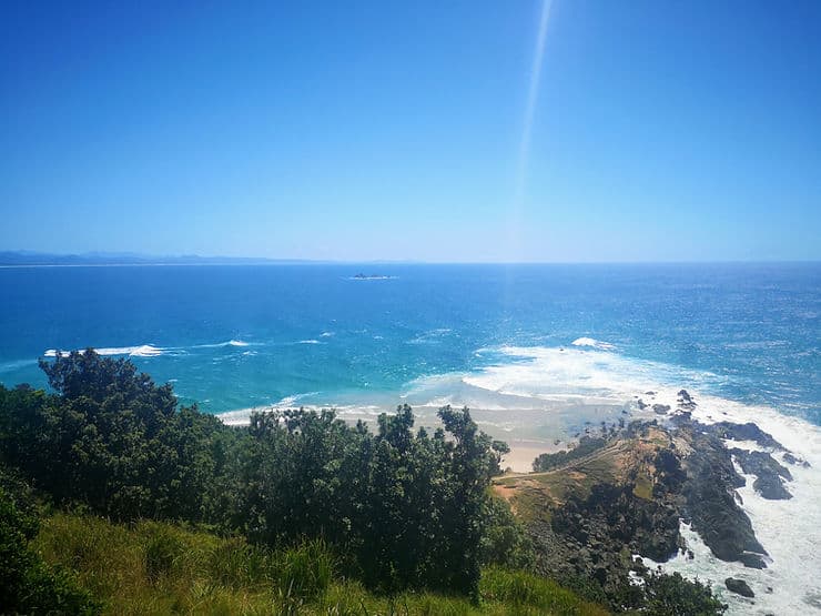 The rocky outcrop of Cape Byron juts out into the blue ocean, as the most easterly point in Mainland Australia