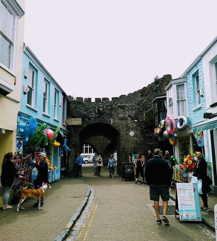 A small section of the historic stone old town wall is still visible between Tenby's pastel coloured shops and cafes