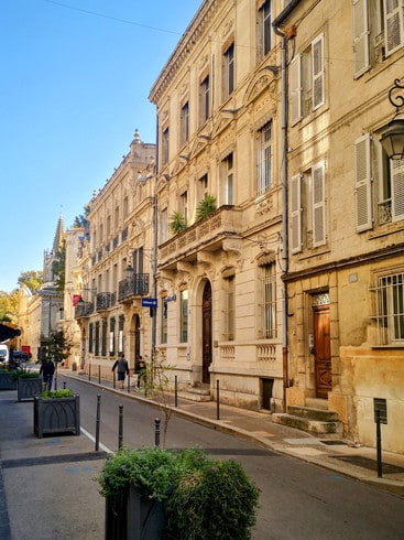 Grand stone houses line a quiet street in Avignon, Provence 