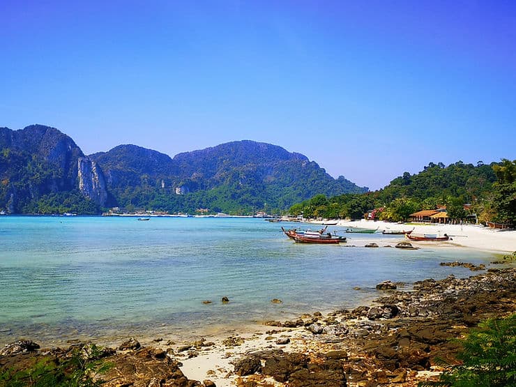 Long tail boats float on the crystal clear surrounding the island of Koh Phi Phi, Thailand 