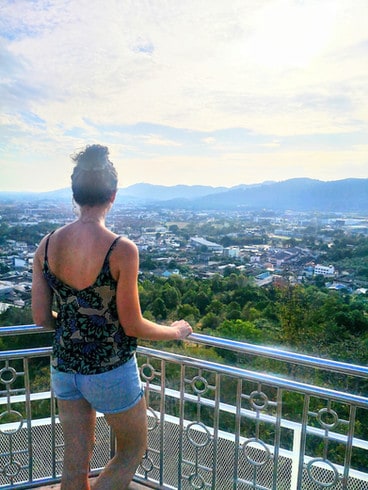 Standing at Khao Rang viewpoint in Phuket, looking out across buildings and the urban areas of town. In the distance you can see mountains on the other side of the island