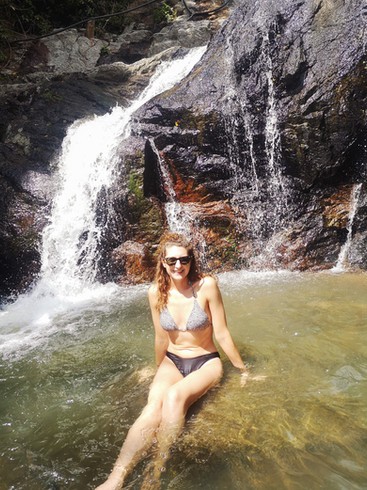 Women bathing in a natural pool at the top of Na Mueang waterfall in Koh Samui.