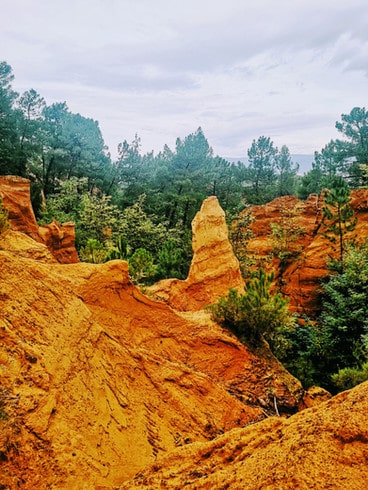 Bright orange rock formations made of ochre in Roussillion's old ochre quarry