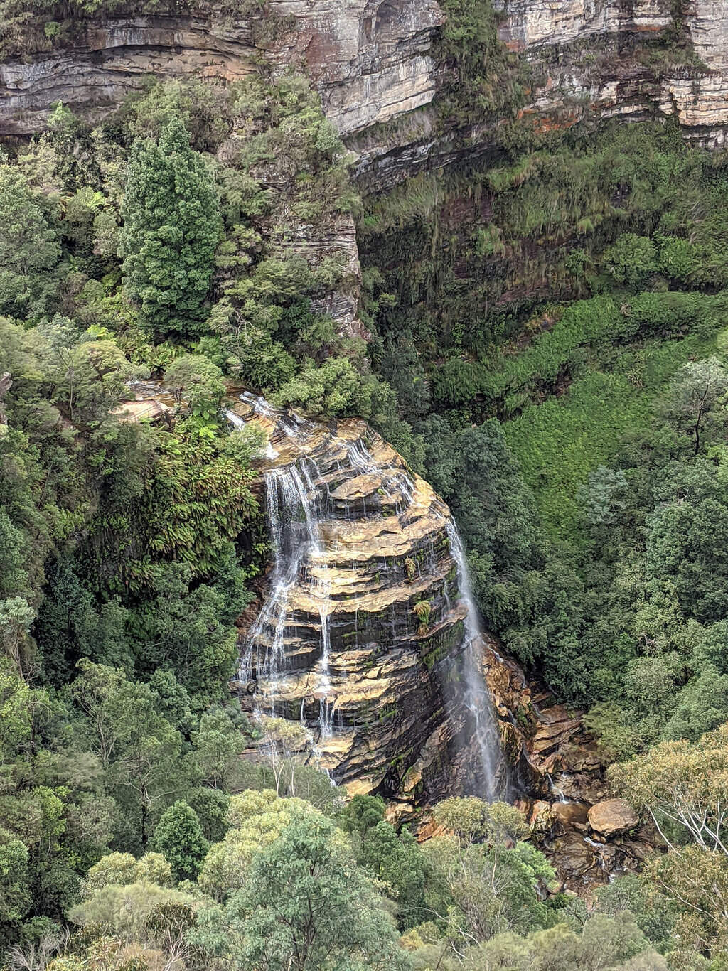 Water fans out and flows down the rocky mountain side at Bridal Veil Falls in the Blue Mountains National Park
