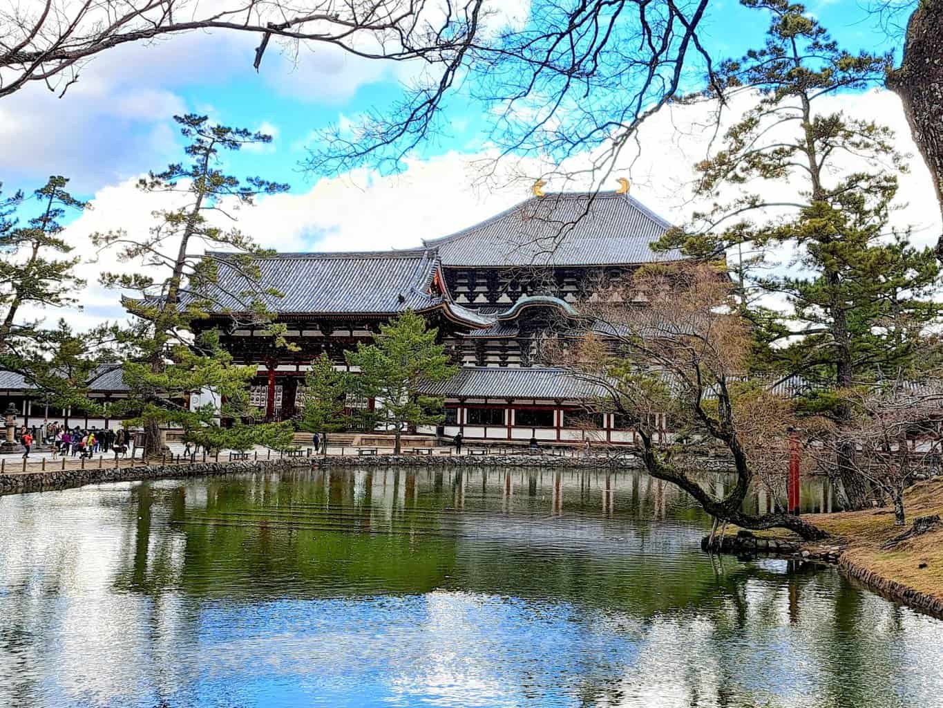 Todai-ji Kondo Hakkaku Toro temple sits in front of a tranquil pond in Nara Deer Park, Japan