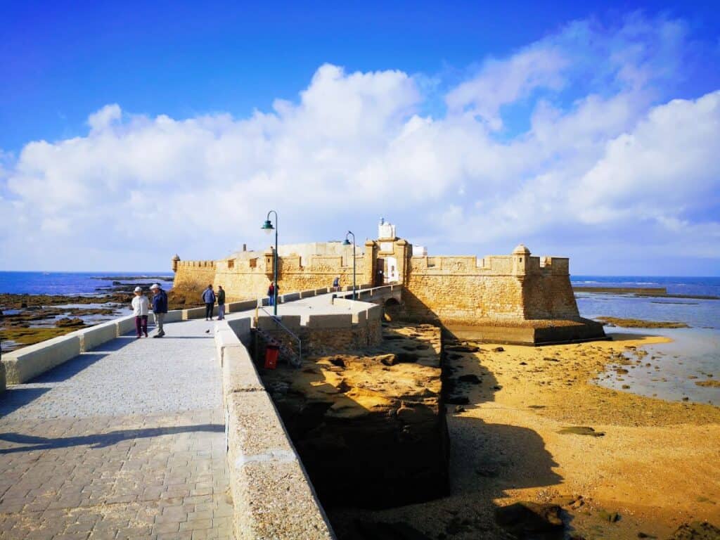 An old stone fort sits on a small outcrop on the coast of Cadiz